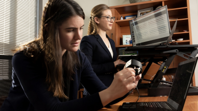 Jessilyn Dunn with PhD student Brinnae Bent who is preparing to download information from a wearable health monitoring device.